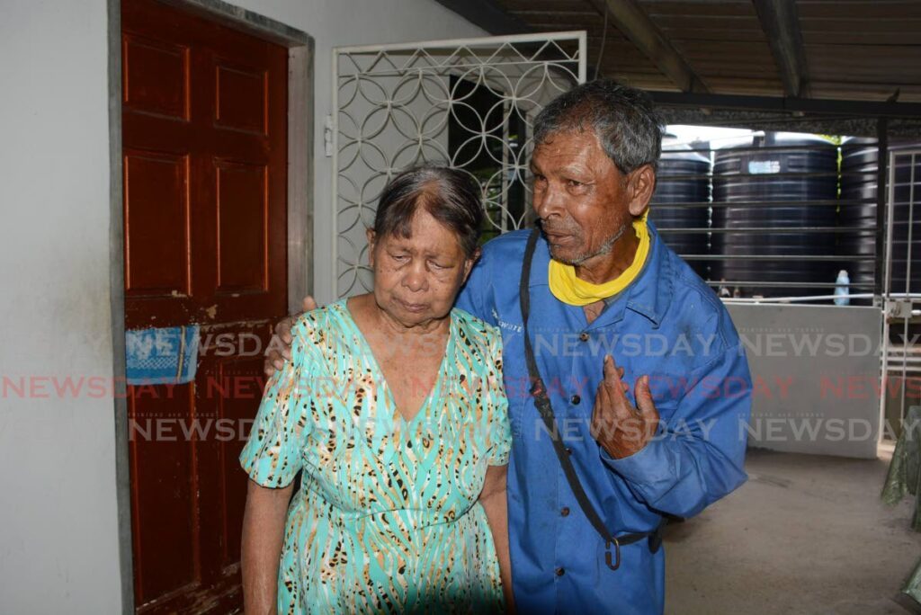 Ramsumair Jagdeo, right, consoles his mother Ramrajiya Beharry at their Ramnarine Trace, San Francique home on February 24. Lucky Jagdeo, another of Beharry's sons, was killed earlier that day. - Photos by Innis Francis