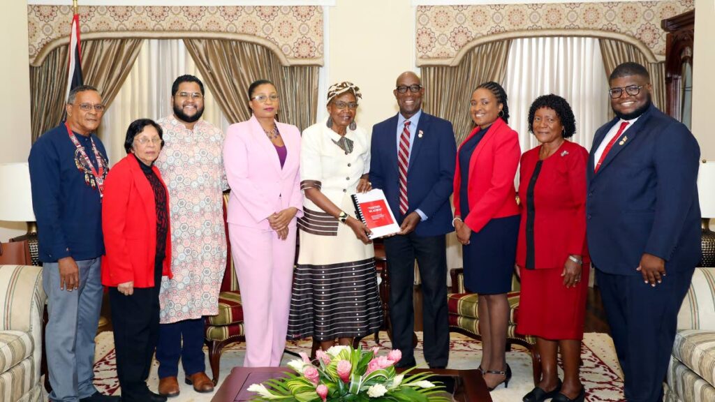 The Prime Minister, centre, receives a report from Dr Rita Pemberton head of the Committee to Review the Placement of Statues, Monuments and Signage at Whitehall, Port of Spain, on February 25. PHOTO COURTESY OPM - 