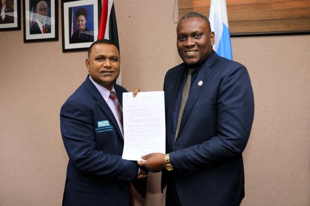 MIC CEO Anil Ramnarine, left, and Central FC president Kieron Edwards after signing the memorandum of agreement.  - 