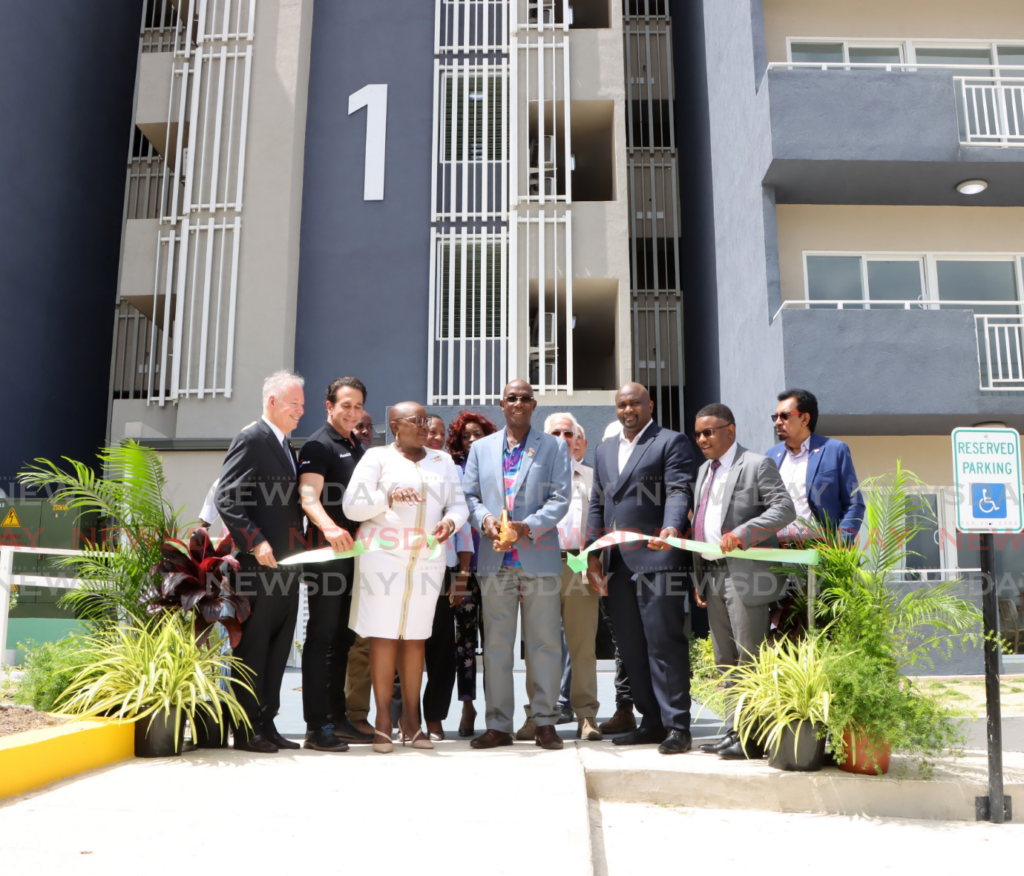 The Prime Minister cuts the ribbon as other government officials look on during a ceremony at The City Heights Housing Development, San Fernando, on February 7. - Photo by Ayanna Kinsale