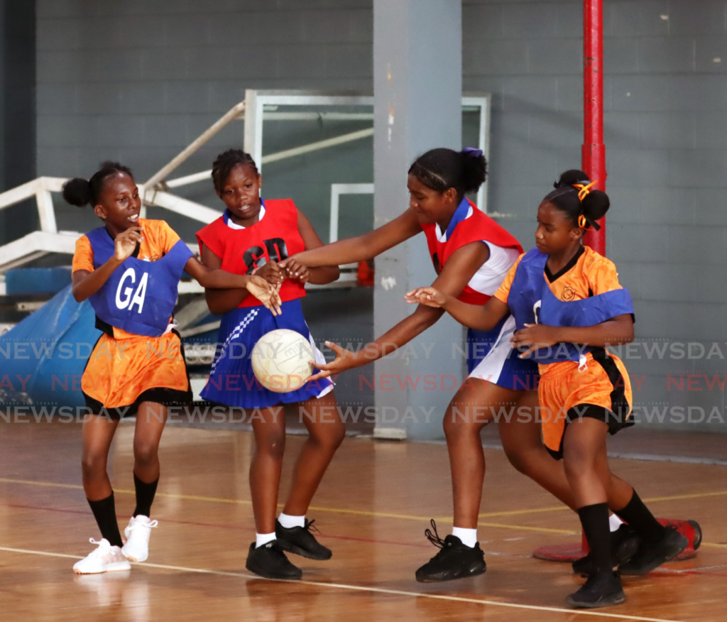 St George East district, in red and blue, and Caroni district go after the ball during an exhibition game at the opening of the National Primary School Netball League at the Maloney Indoor Sports Arena, Maloney on February 14. - Photo by Ayanna Kinsale