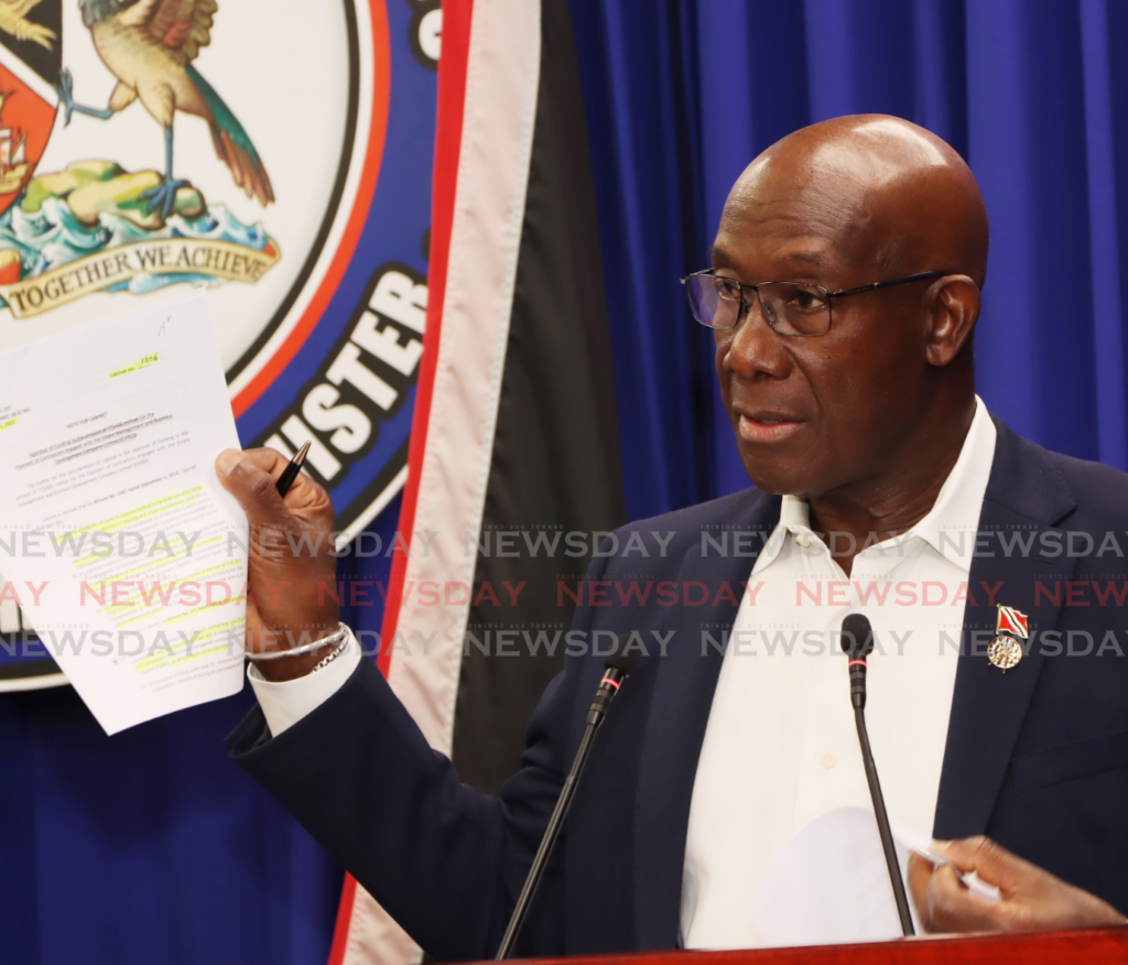 The Prime Minister displays a document during a media conference at White Hall, Queen’s Park West, Port of Spain, on February 14. - Photo by Ayanna Kinsale