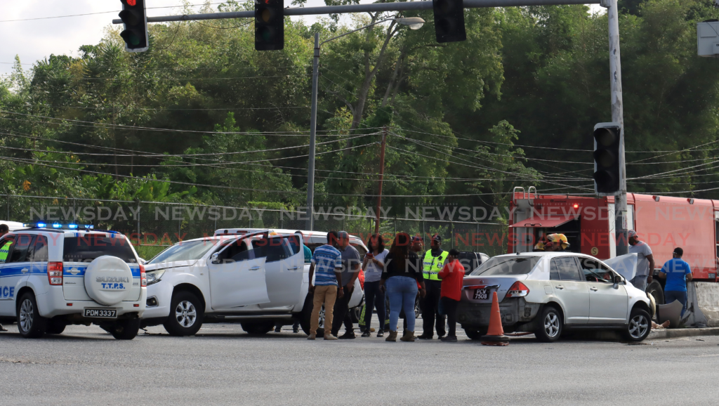 Police, emergency personnel and passersby help people injured in accident at Piarco in February 2024. File photo