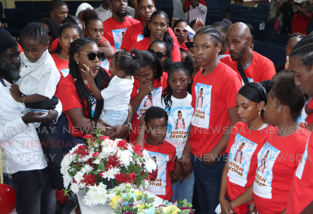 The family and friends of Jereem George gather around his coffin at the Bethel World Outreach Ministries, Arima on January 3. At left, is his father and mother, Jason Myler and Genieel George. - Photo by Angelo Marcelle