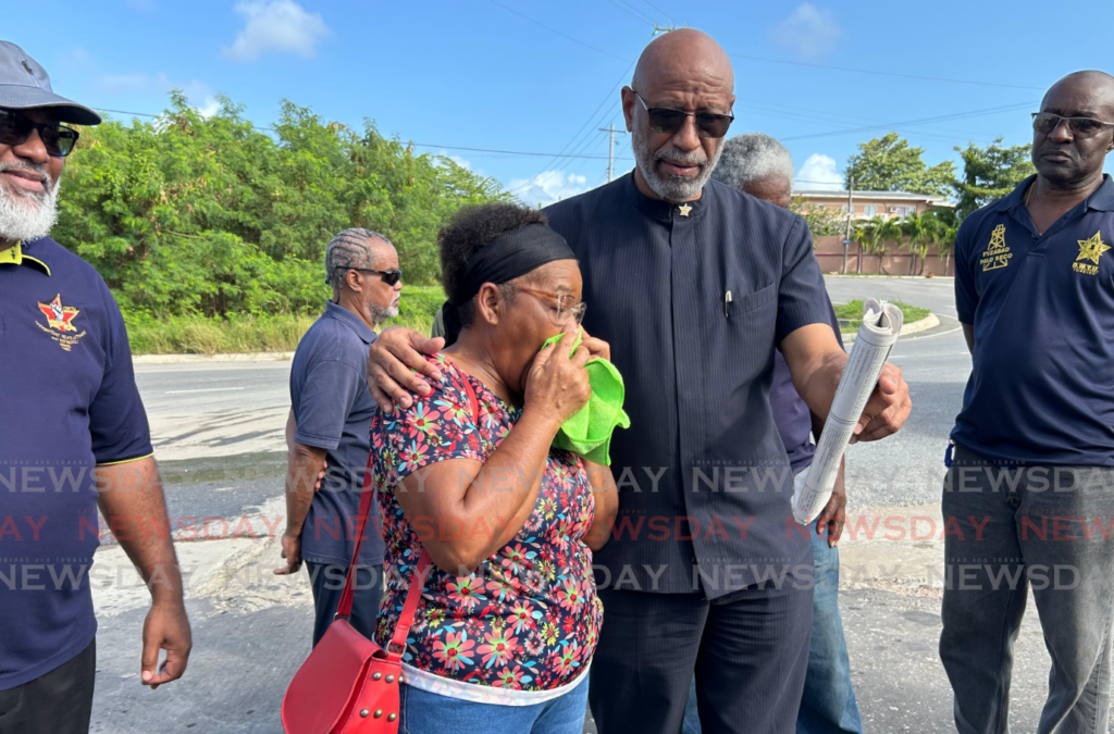 OWTU president general Ancel Roget consoles missing Well Services Ltd employee Pete Phillip's mother outside the company on February 4. Phillip has been missing 44 days now since the company's Rig 110 partially collapsed on December 22. - Photo by Rishard Khan