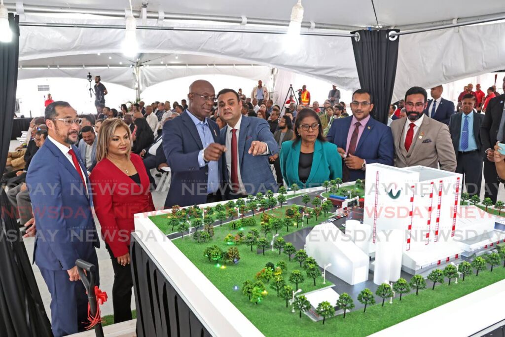 Energy Minister Stuart Young, left;  Lydia Mohammed, director of Nutrimix; Prime Minister Dr Keith Rowley; Ronnie Mohammed, CEO, Nutrimix;  Trade Minister Paula Gopee-Scoon; Minister in the Ministry of Agriculture, Avinash Singh; and Minister in the Ministry of Transport Richie Sookhai, look at the model of what Nutrimix's  animal and pet food plant will look like at the Point Lisas Industrial Estate on February 25.  - Photo by Lincoln Holder 