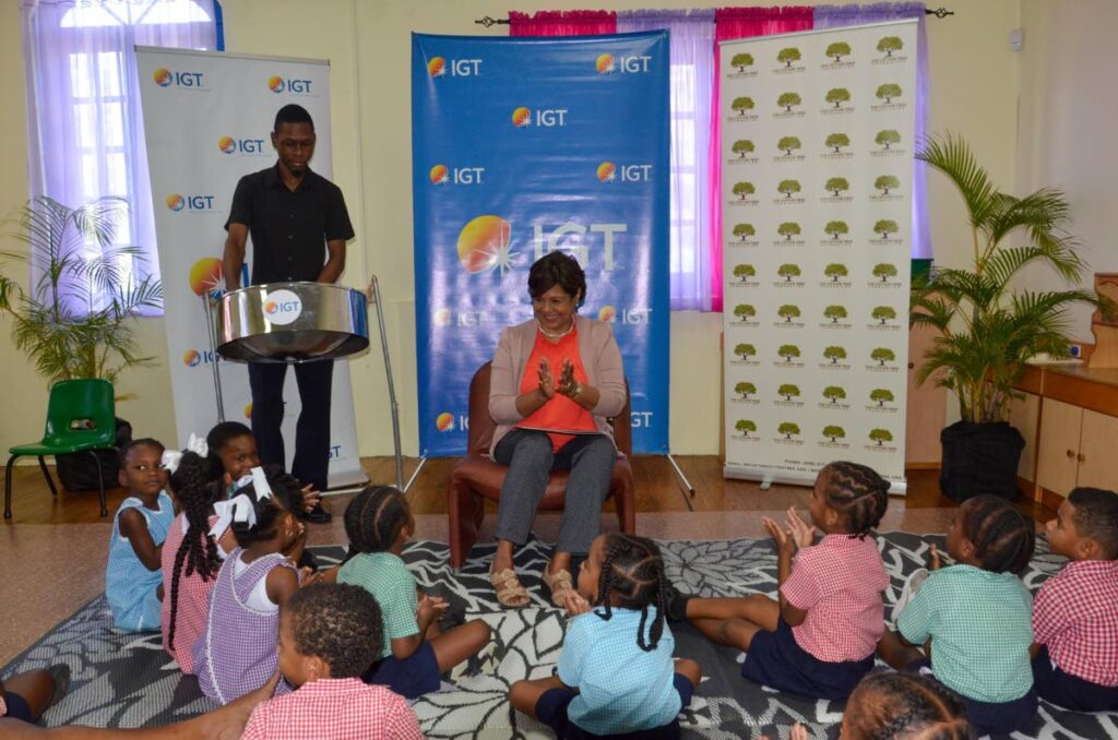 IGT P&T regional senior manager for the Caribbean Shavindra Tewarie-Singh joins the Cotton Tree Foundation preschoolers as they clap and sing along to soca tunes played on the pan by Chavez Benjamin. - 