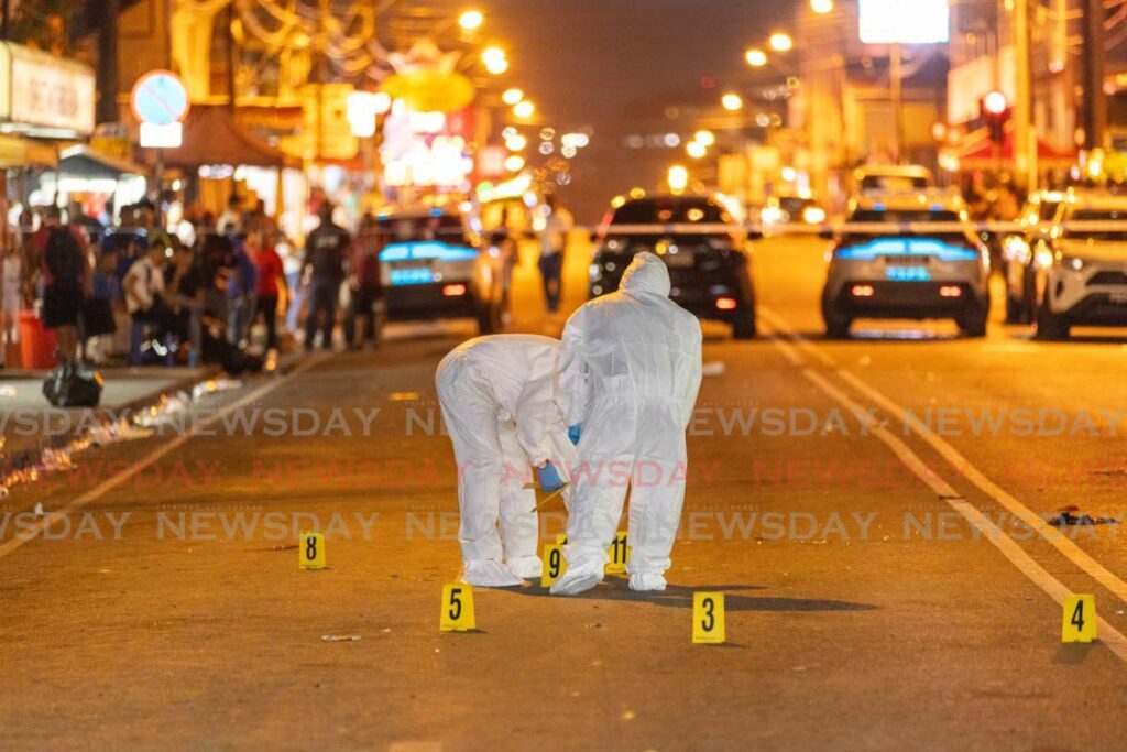 Crime scene investigators collect evidence in St James after a man was shot dead during Carnival festivities on March 4. Three others were wounded during the incident. - Photo by Jeff K Mayers