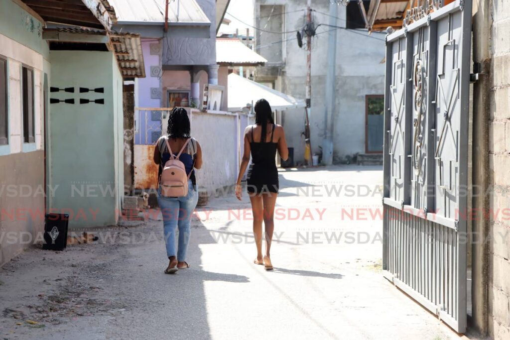 Residents walk along Pioneer Drive in Sea Lots on March 6.  - Photo by Ayanna Kinsale