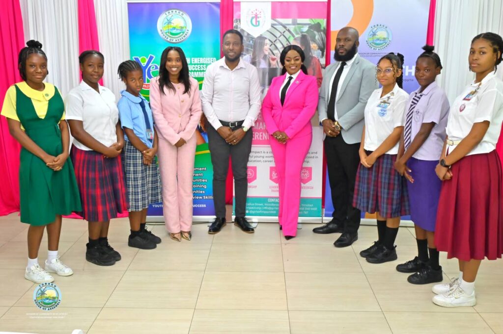 From left, Renee Atwell, founder of Girls of Impact TT, Assemblyman Joel Sampson, Secretary of Community Development, Youth Development and Sport, Assemblyman Zorisha Hackett, Secretary for Education, Research and Technology and Keigon Denoon, Programme Administrator, YES Programme, are flanked by young girls representing various high schools in Tobago at the International Women’s Day symposium on March 7. - Photo courtesy THA