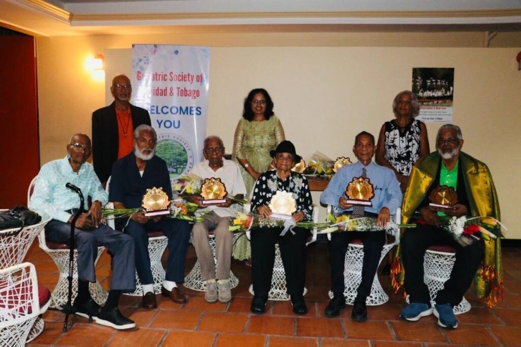 Bob Gopee, left,  Toussaint Singh, Harry Lalla, Wilma Cropper, Albert Pantin and Imam Haji Ahamad Hosein (ASJA) with GSTT team standing  - Fr Martin Sirju , Dr Lavanya Thondavada and  Claire Gittens. - 