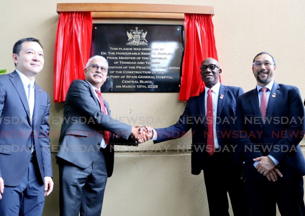 Prime Minister Keith Rowley shakes hands with Health Minister Terrence Deyalsingh at a ceremony to mark the practical completion of the 540-bed Central Block of the Port of Spain General Hospital on March 10. Looking on are Chargé D’affaires Yang Han of the Embassy of the People's Republic of China, left, and Minister of Energy and Energy Affairs Stuart Young. - Photo by Ayanna Kinsale