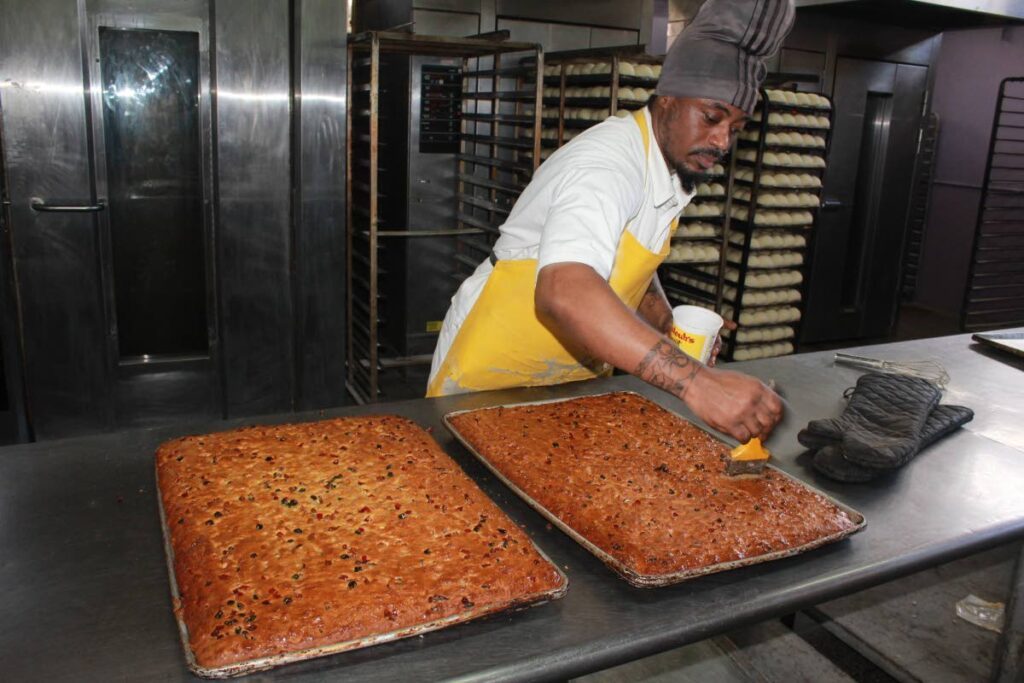 Jalon Robinson adds glaze to sweetbread at the Maximum Security Prison bakery in Arouca.  - Photo courtesy Prison Service