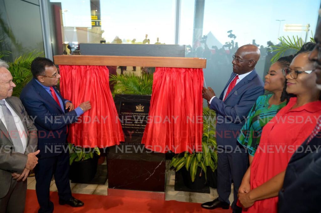 Prime Minister Dr Keith Rowley, right, and Works and Transport Minister Rohan Sinanan unveil a plaque to mark the practical completion of the new terminal building of the ANR International Airport, Crown Point, Tobago on March 15. - Photo by Visual Styles