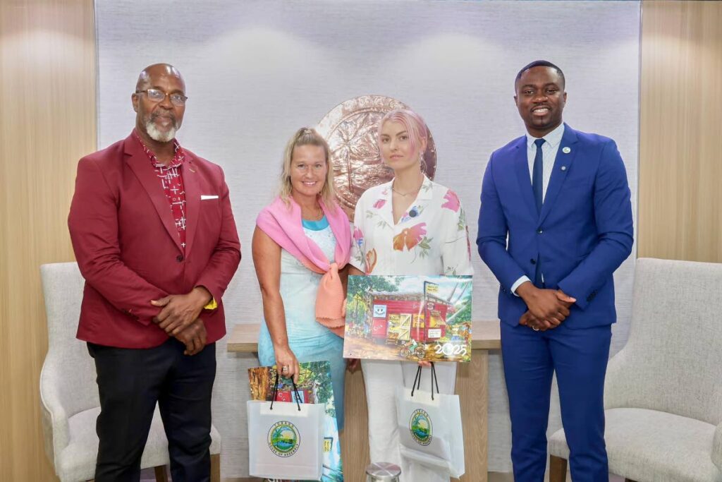 Chief Secretary Farley Augustine, right, and Assistant Secretary Sonny Craig, pay tribute to tourists Anna Hospedales of Canada, second from left, and Sarah Perrson of Sweden. - OCS