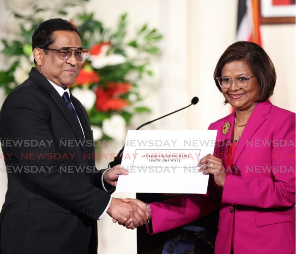 Vishnu Dhanpaul accepts his instrument of appointment from President Christine Kangaloo at the President's House on March 17. - Photo by Jeff K Mayers