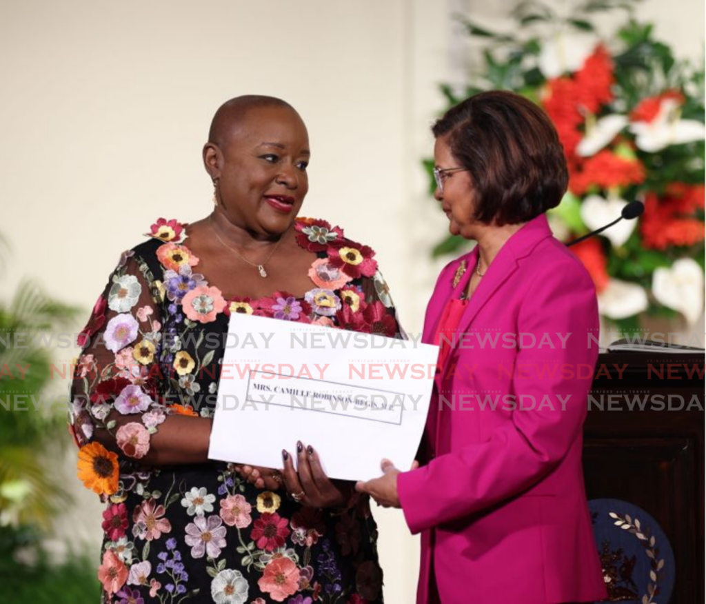 Camille Robinson-Regis receives her instrument of appointment from President Christine Kangloo at the President's House on March 17. - Photo by Jeff K Mayers