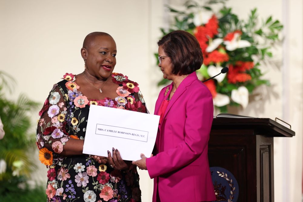 Camille Robinson-Regis receives her instrument of appointment from President Christine Kangloo at the President's House on March 17. - Photo by Jeff K Mayers